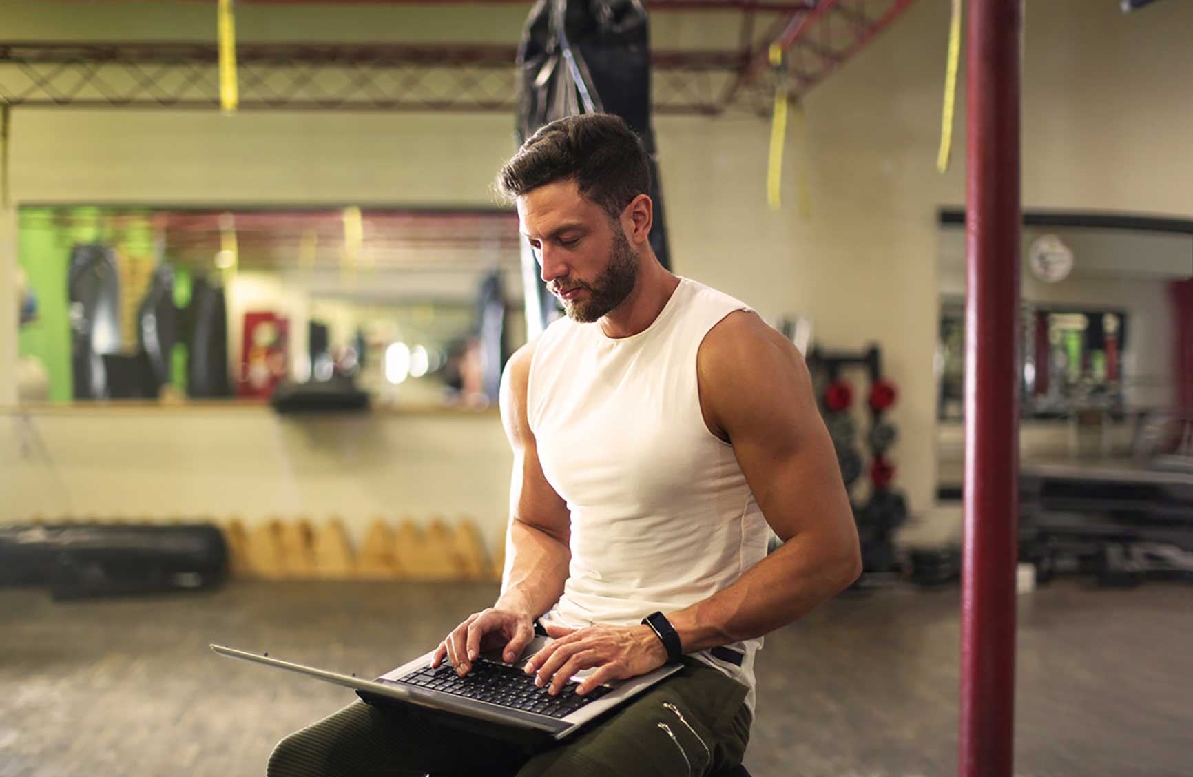 a male fitness studio owner working on his laptop