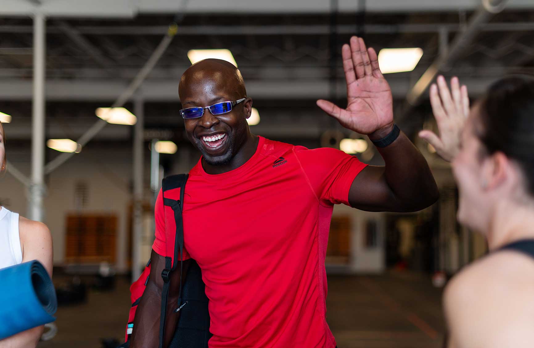 an African American athlete giving high-five to his friend at a gym