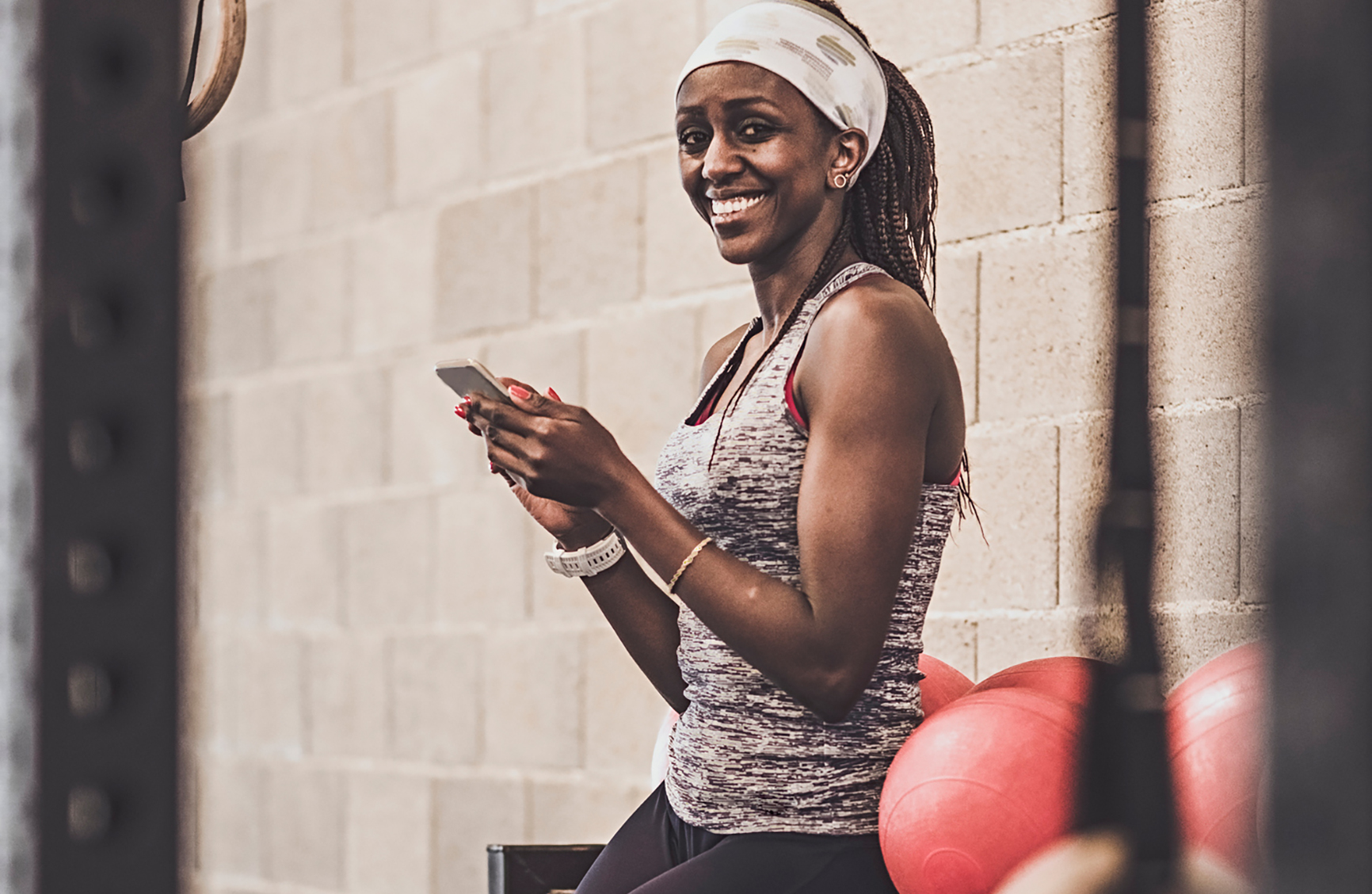 happy women in gym looking at her phone