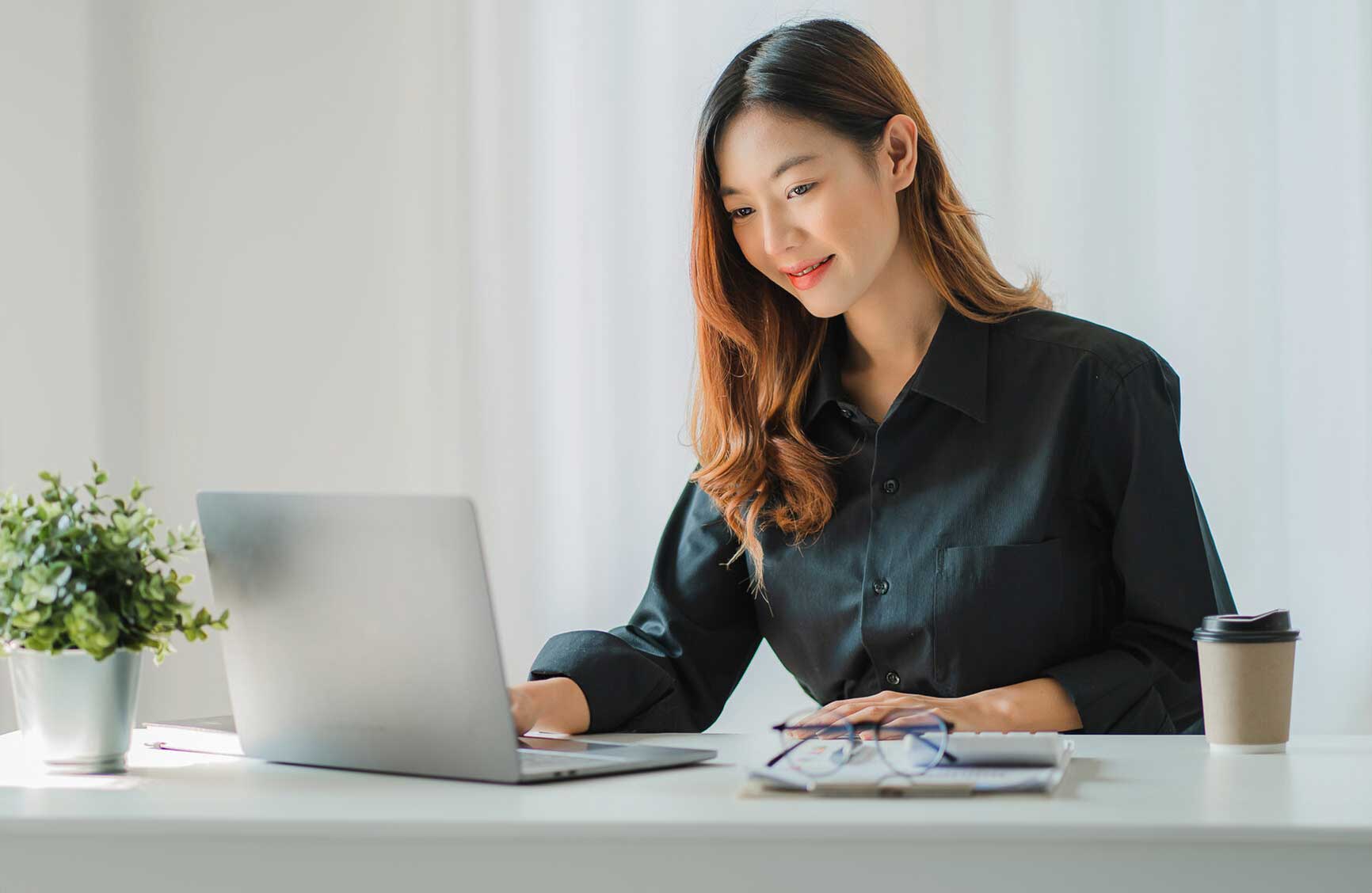 Young Asian businesswoman using calculator and laptop for math finance on wooden table, tax, accounting, statistical report.