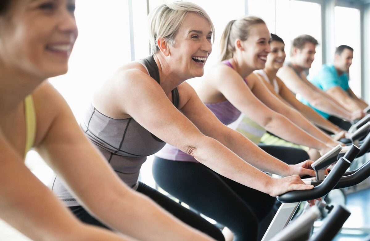 People exercising on stationary bikes in fitness class