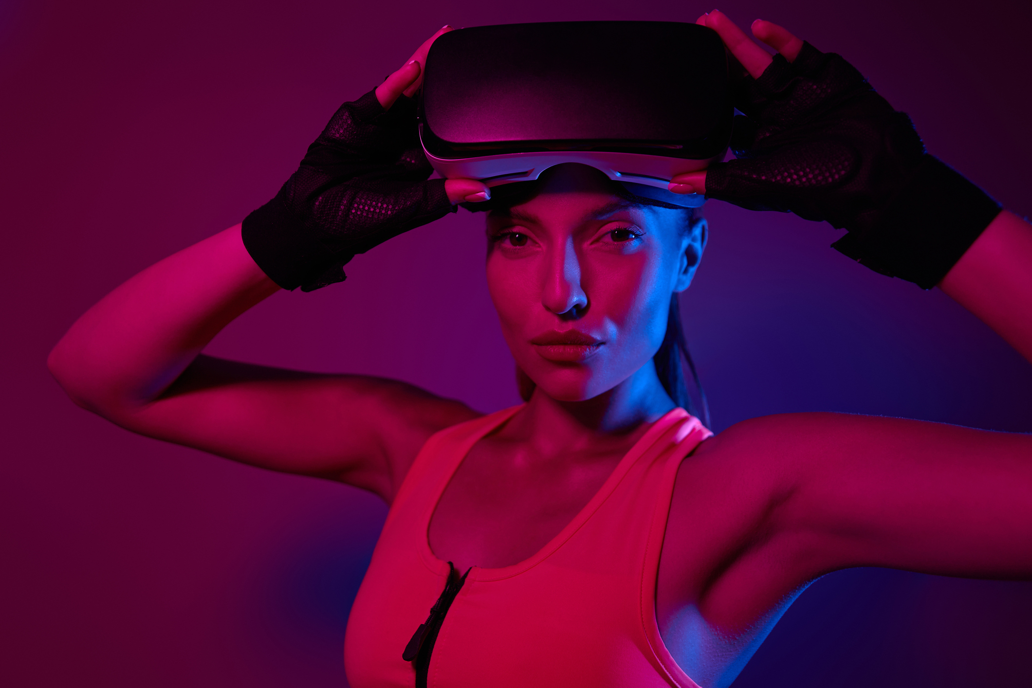 Attractive young woman in sports clothing wearing virtual reality glasses