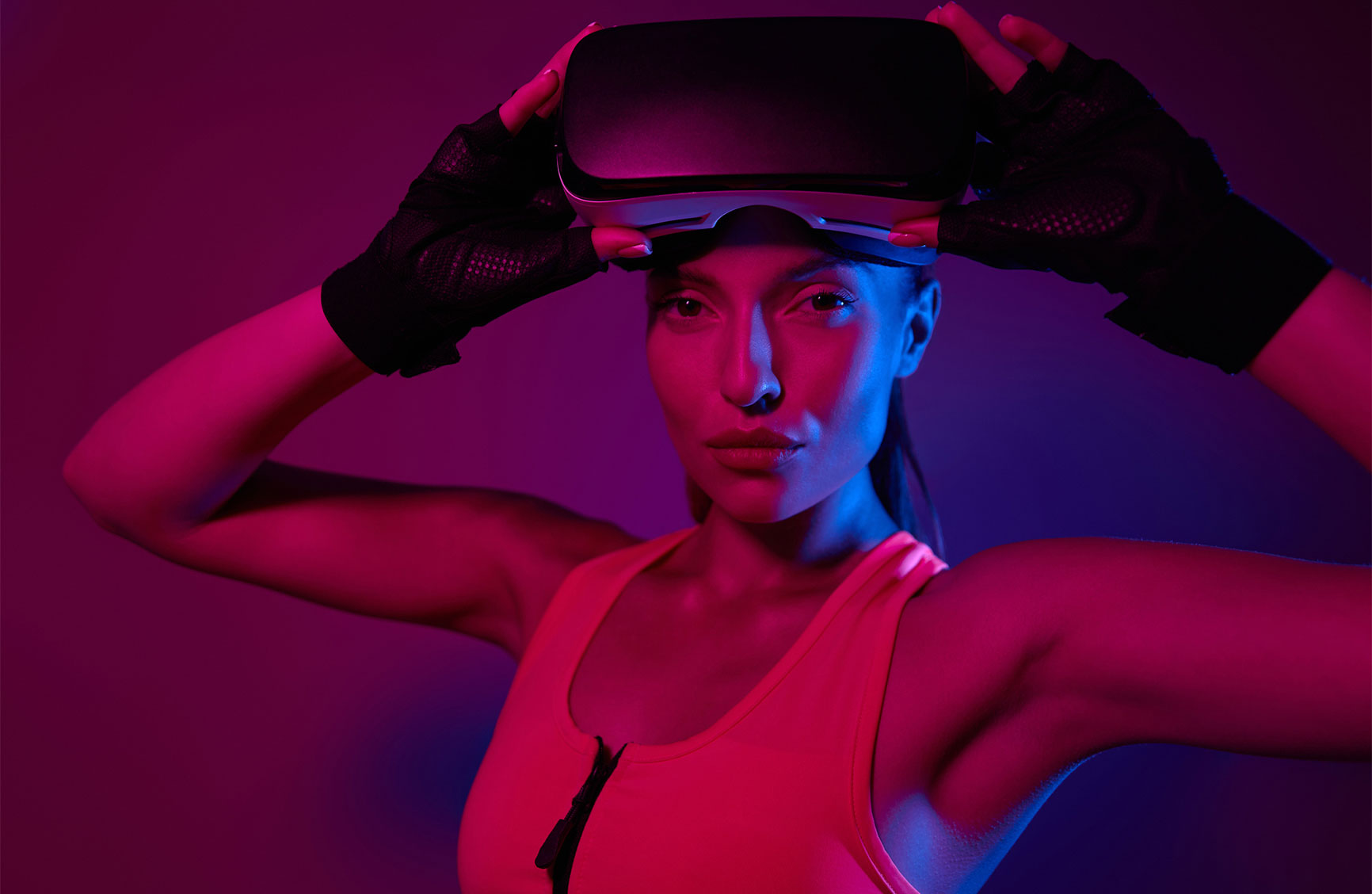 Attractive young woman in sports clothing wearing virtual reality glasses