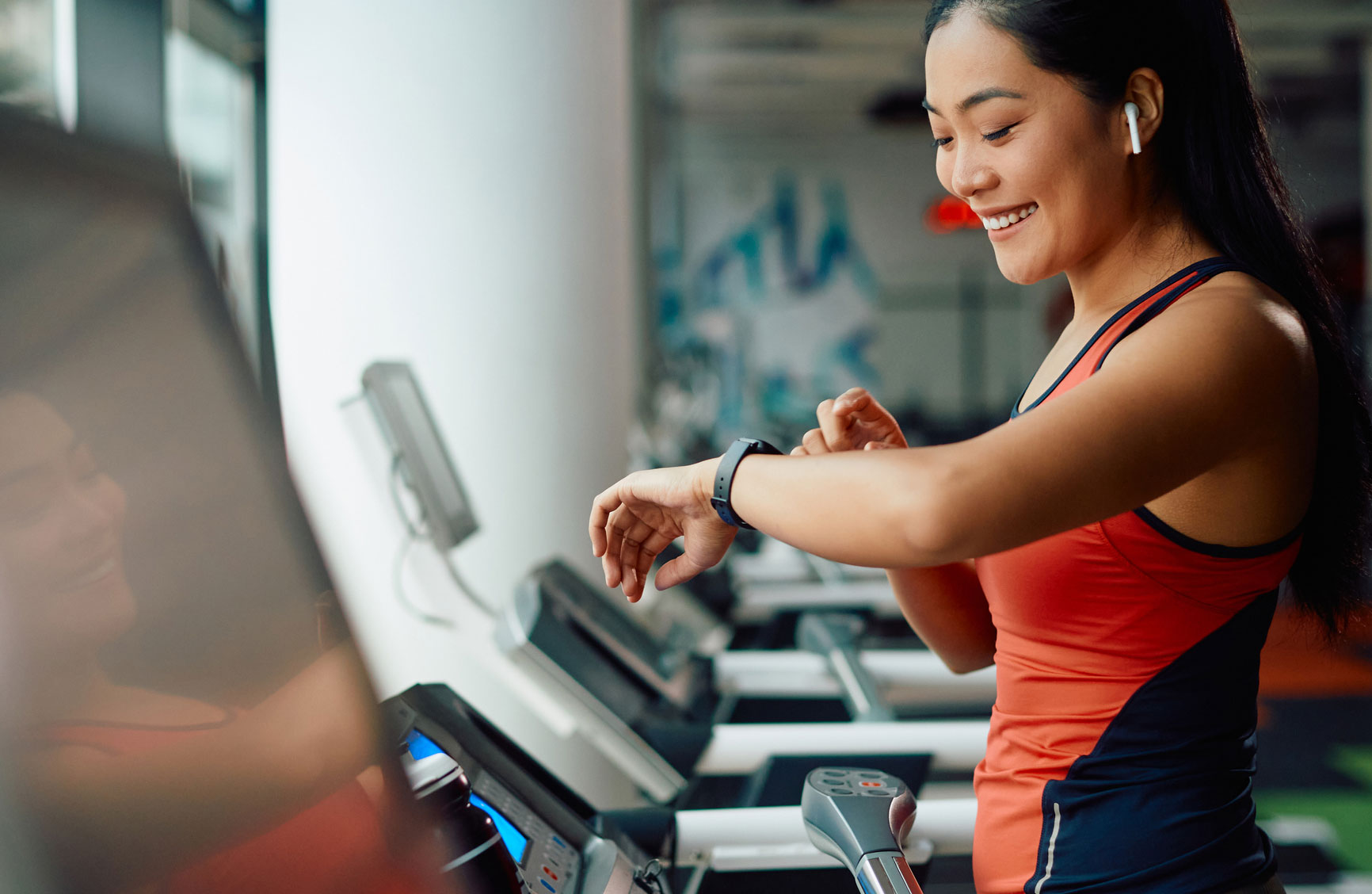 a girl walking on treadmill while checking her smart watch