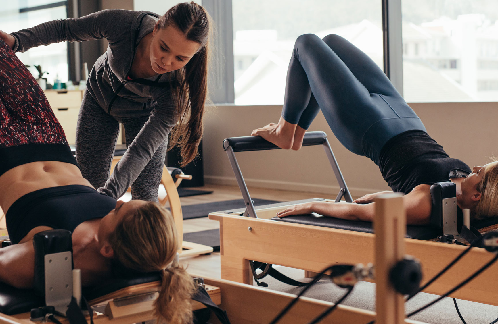 A pilates instructor helping students