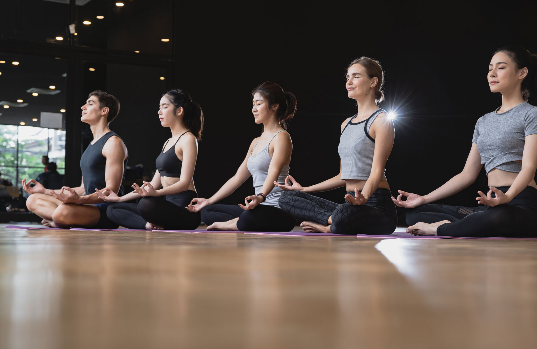 A group of people meditating at a yoga studio