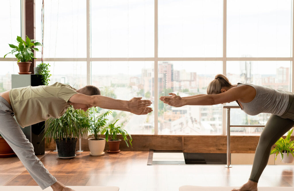 a man and a woman doing yoga indoor