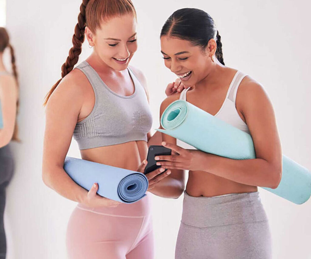 Two ladies looking at a smartphone after yoga