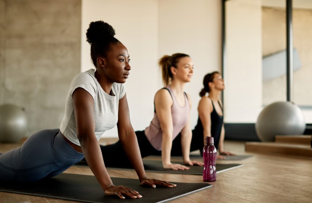 Three ladies doing yoga in a gym