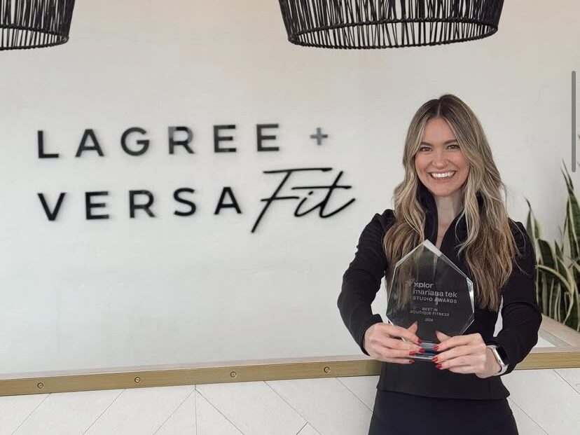 Raquel Marquez, owner of Lagree + Versa Fit, proudly accepting Mariana Tek’s Community Choice Award, recognizing her studio’s outstanding impact and engagement.